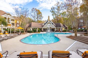 A pool surrounded by chairs and trees  at Waverly Place, South Carolina